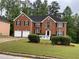 Brick two-story home boasts an attached two-car garage and a lush green lawn at 787 Wynbrooke Pkwy, Stone Mountain, GA 30087