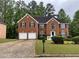 Brick two-story home boasts an attached two-car garage and a well manicured lawn at 787 Wynbrooke Pkwy, Stone Mountain, GA 30087