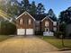 Two-story brick home featuring a two-car garage and a well-manicured lawn at 787 Wynbrooke Pkwy, Stone Mountain, GA 30087