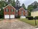 Brick two-story home boasts an attached two-car garage and a well manicured lawn at 787 Wynbrooke Pkwy, Stone Mountain, GA 30087