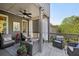 Cozy outdoor living on a covered back deck featuring comfortable seating, ceiling fan, and decorative accents at 8385 E Village School E Dr, Cumming, GA 30041