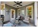 Cozy covered deck with ample seating and charming decorative touches at 8385 E Village School E Dr, Cumming, GA 30041