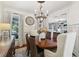 Elegant dining room with hardwood floors, stylish chandelier, and views into the living room at 8385 E Village School E Dr, Cumming, GA 30041