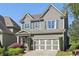 Attractive two-story home featuring a gray exterior, complementary shutters, and a well-maintained front yard at 8385 E Village School E Dr, Cumming, GA 30041