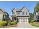 Beautiful gray two-story home with well-manicured landscaping, a two-car garage, and a welcoming facade at 8385 E Village School E Dr, Cumming, GA 30041