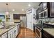 A kitchen shows granite countertops, stainless steel appliances, and dark wood cabinets at 8385 E Village School E Dr, Cumming, GA 30041