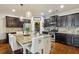 A kitchen featuring stainless steel appliances, granite countertops, dark cabinets, and a center island at 8385 E Village School E Dr, Cumming, GA 30041