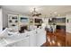 Open-concept living space with hardwood floors, fireplace, white sofas, and seamless flow to the kitchen at 8385 E Village School E Dr, Cumming, GA 30041