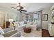 Cozy living room with a plush white sofa, decorative pillows, an ottoman, and lots of natural light at 8385 E Village School E Dr, Cumming, GA 30041