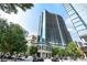 Modern high-rise building exterior featuring glass facade, lush landscaping, and street views at 1080 Peachtree Ne St # 1504, Atlanta, GA 30309