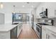 Contemporary kitchen with stainless appliances, white cabinets, island sink, and an attached living area with city views at 1080 Peachtree Ne St # 1504, Atlanta, GA 30309