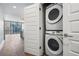 Hallway closet features stackable washer and dryer with white doors at 1080 Peachtree Ne St # 1504, Atlanta, GA 30309