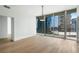 Open-concept living room with hardwood floors, large windows offering city views, and modern lighting fixtures at 1080 Peachtree Ne St # 1504, Atlanta, GA 30309