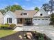 Charming home featuring white board and batten siding, stone accents, beautiful landscaping, and a two-car garage at 1127 Bank Se St, Smyrna, GA 30080
