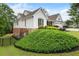 Side view of the home showing the manicured landscaping, brick foundation, and white siding at 1127 Bank Se St, Smyrna, GA 30080