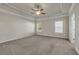 Spacious bedroom featuring tray ceiling, ceiling fan, and neutral carpet at 5140 Woodline View Cir, Auburn, GA 30011