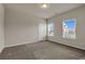 Spacious bedroom with carpet floors, two windows, and neutral walls at 5140 Woodline View Cir, Auburn, GA 30011