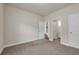 Neutral bedroom showcasing plush carpet, with doorways to closet and bathroom at 5140 Woodline View Cir, Auburn, GA 30011