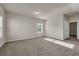 Bedroom with sunlit windows, neutral carpet, and door leading to closet at 5140 Woodline View Cir, Auburn, GA 30011