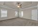 Large primary bedroom showcasing tray ceiling and neutral carpeting at 5140 Woodline View Cir, Auburn, GA 30011