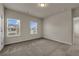 Well-lit bedroom with two windows, carpet floors, and access to another room at 5140 Woodline View Cir, Auburn, GA 30011
