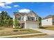 Charming two-story home with a brick facade, black shutters, attached two car garage and well maintained lawn at 5140 Woodline View Cir, Auburn, GA 30011