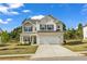 Charming two-story home with a brick facade, black shutters, attached two car garage and well maintained lawn at 5140 Woodline View Cir, Auburn, GA 30011