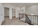 Upstairs hallway with hardwood stairs and doors to bedrooms and laundry room at 5140 Woodline View Cir, Auburn, GA 30011