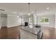 Open-concept kitchen and living room layout, filled with natural light and modern appliances at 5140 Woodline View Cir, Auburn, GA 30011