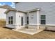 Back view of two-story home with vinyl siding and a small patio at 5140 Woodline View Cir, Auburn, GA 30011
