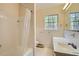 Bathroom with a bathtub, shower, white tiling, a toilet, vanity, mirror, and window overlooking outdoor scenery at 6435 E Glen Rd, Lithonia, GA 30038