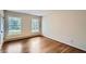 Bright bedroom featuring hardwood floors, closet and two windows with views of the green outdoor scenery at 6435 E Glen Rd, Lithonia, GA 30038