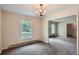 Bright dining room with neutral carpet, a classic chandelier, and views of the yard at 6435 E Glen Rd, Lithonia, GA 30038