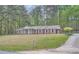 Quaint one-story brick home nestled on a hill with traditional white columns and shutters at 6435 E Glen Rd, Lithonia, GA 30038