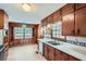 Functional kitchen featuring wood cabinetry, tile countertops, and a cozy eat-in area at 6435 E Glen Rd, Lithonia, GA 30038