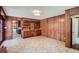 Open-concept living room with tile flooring, wood paneling, and built-in shelving at 6435 E Glen Rd, Lithonia, GA 30038