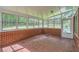 A sunroom with brick walls, mosaic floors, and multiple windows offering backyard views at 6435 E Glen Rd, Lithonia, GA 30038