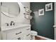 Powder room with dark accent wall, modern vanity and round mirror at 307 Downing Creek Trl, Canton, GA 30114