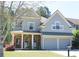 Charming two-story home with a covered front porch, stone accents, and a two-car garage at 307 Downing Creek Trl, Canton, GA 30114