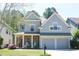 Charming two-story home with a covered front porch, stone accents, and a two-car garage at 307 Downing Creek Trl, Canton, GA 30114
