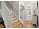 Bright foyer featuring hardwood floors, staircase, and a decorative light fixture at 307 Downing Creek Trl, Canton, GA 30114