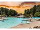 Large community swimming pool featuring a waterfall and ample lounge seating at sunset at 307 Downing Creek Trl, Canton, GA 30114