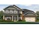 Charming two-story brick home with a covered front porch and a two-car garage with a well-manicured lawn at 5009 Fairview Cir, Villa Rica, GA 30180