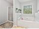 Bright bathroom featuring a shower, large bathtub and window at 642 Towering Pine Trl, Lawrenceville, GA 30045