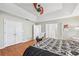 Comfortable bedroom featuring hardwood floors, tray ceilings, fan and adjacent bathroom access at 642 Towering Pine Trl, Lawrenceville, GA 30045