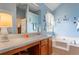 This bathroom features a soaking tub, a vanity, and blue walls at 726 Fir Chase, Fairburn, GA 30213