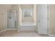 Bright bathroom featuring a glass shower, a large soaking tub, and neutral tile flooring at 902 Brumley Nw Ln, Kennesaw, GA 30152