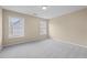 Neutral bedroom with plush gray carpeting and abundant natural light from two large windows at 902 Brumley Nw Ln, Kennesaw, GA 30152
