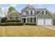 Charming two-story home with a manicured lawn and a two-car garage and stone detailing at 902 Brumley Nw Ln, Kennesaw, GA 30152