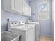 Functional laundry room with washer, dryer, utility sink, and storage cabinets at 902 Brumley Nw Ln, Kennesaw, GA 30152